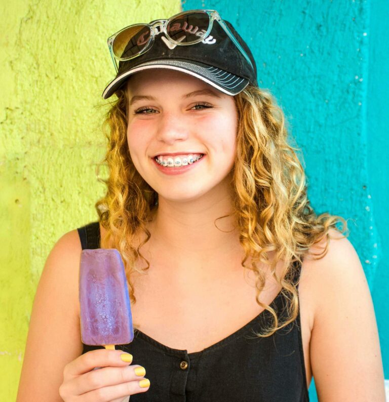 teen eating a popsicle with braces instead of invisalign